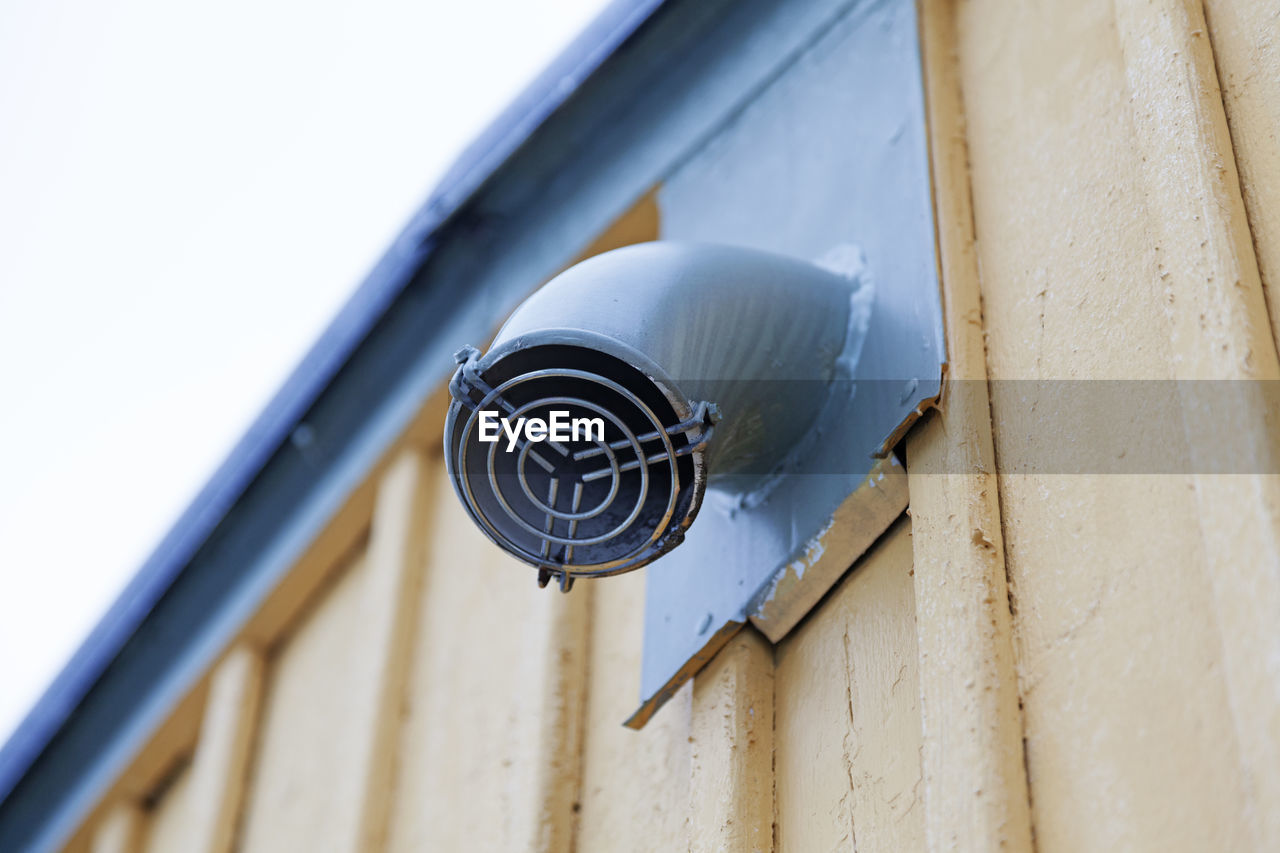 A small fan mounted on the house facade