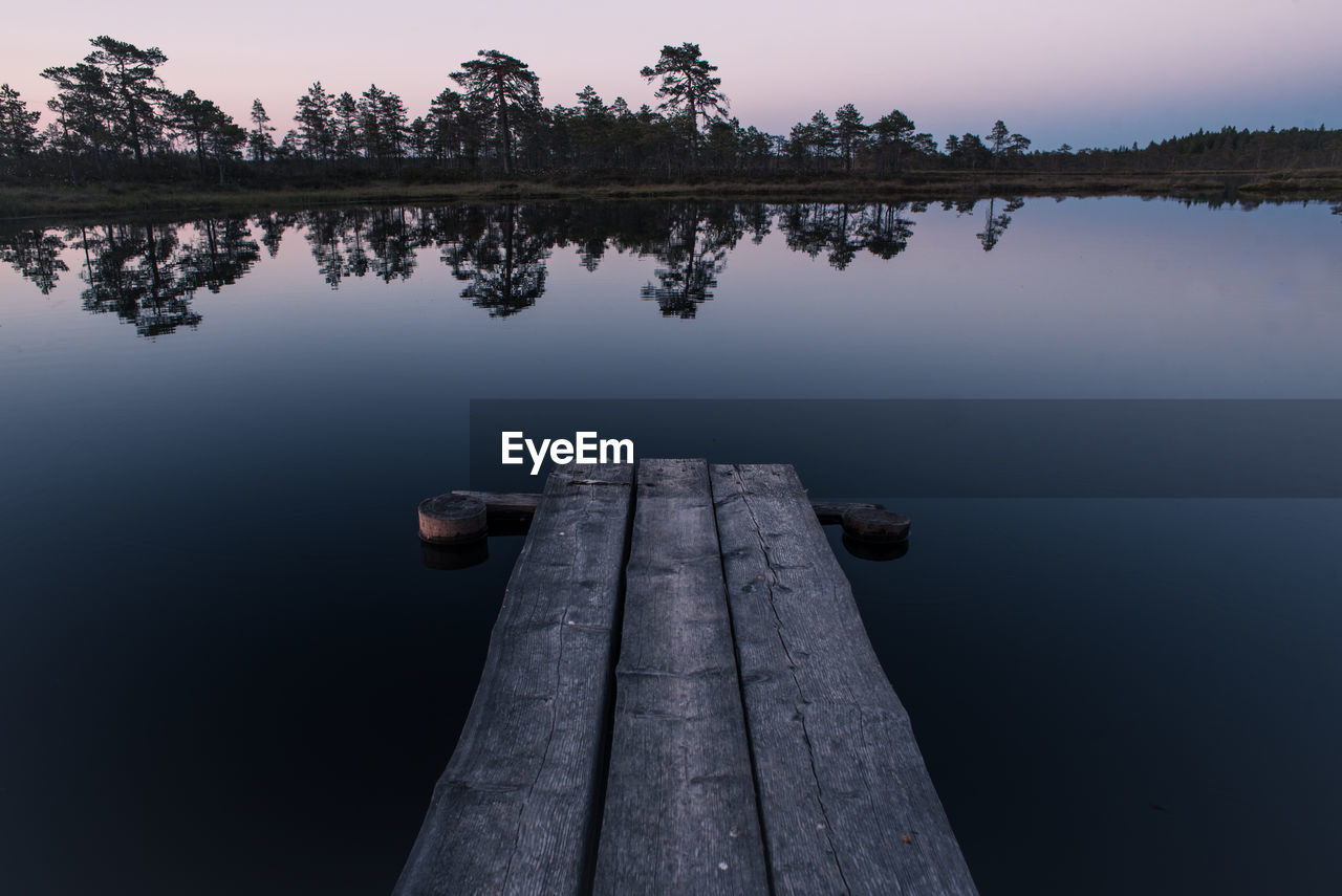 Wooden pier on lake against sky