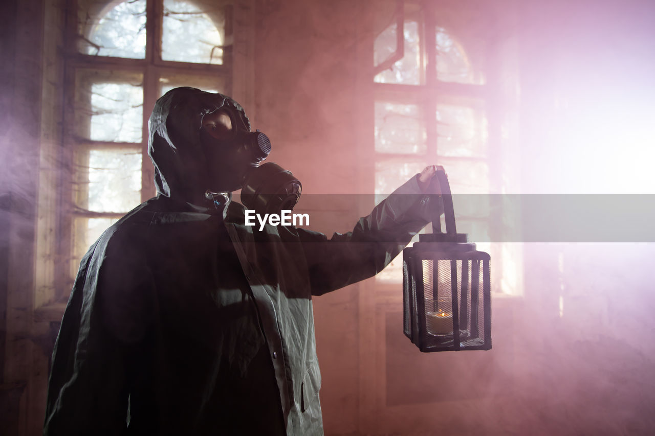 MAN PHOTOGRAPHING THROUGH WINDOW IN SUNLIGHT