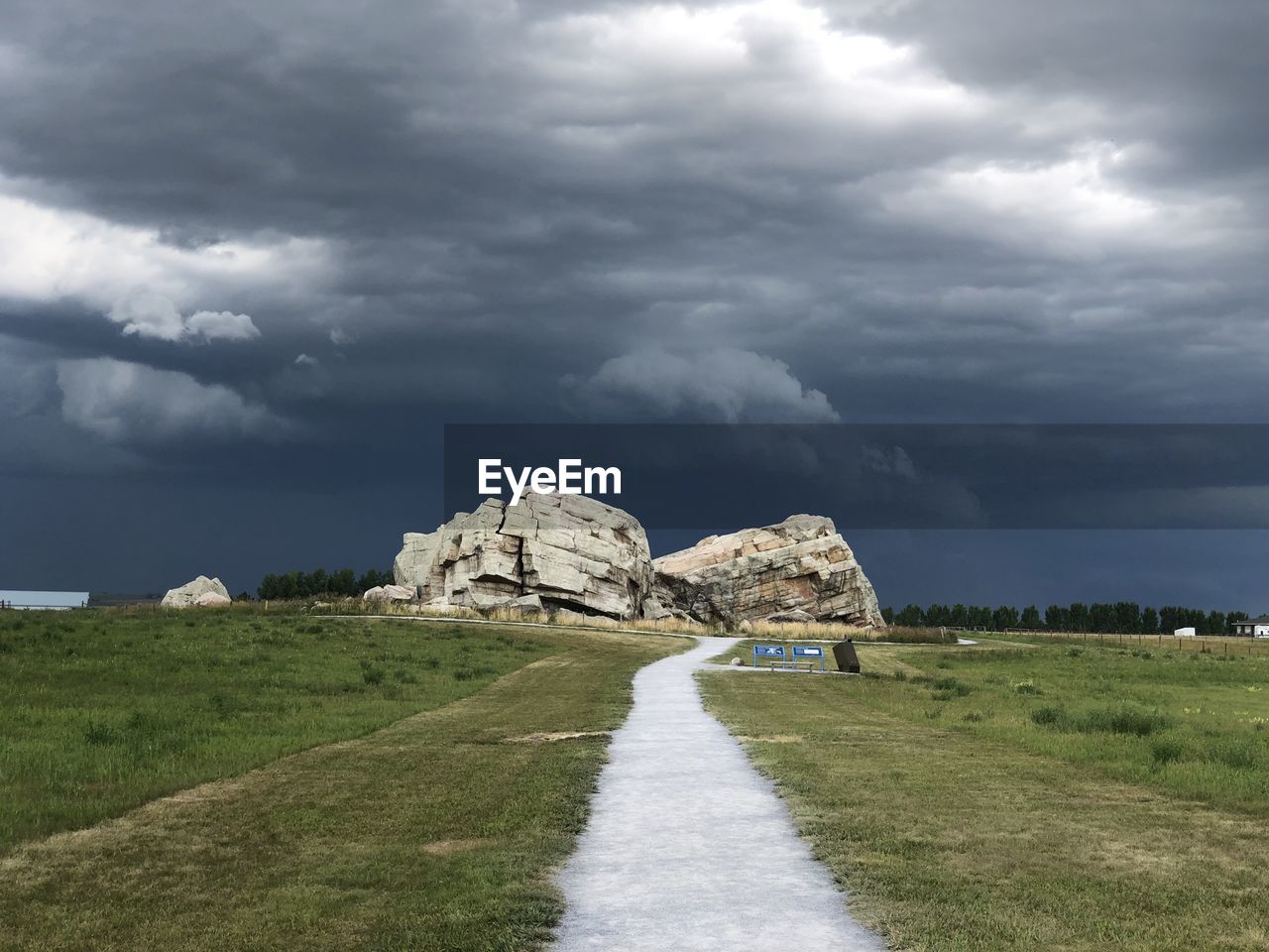 Built structure on land by road against sky