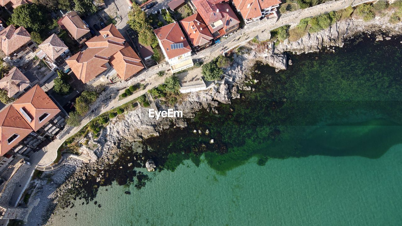 HIGH ANGLE VIEW OF RIVER AMIDST BUILDINGS IN CITY