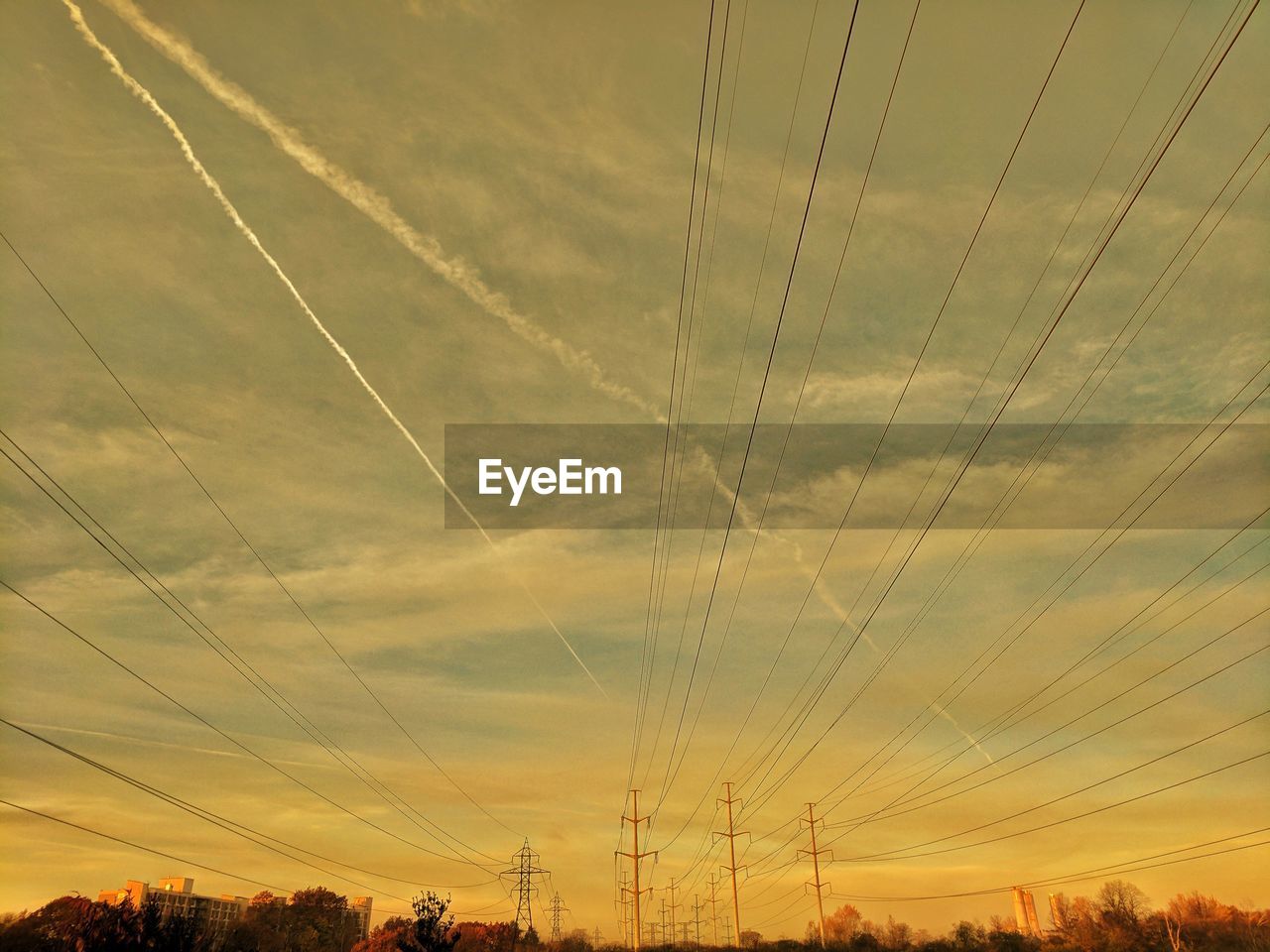 Low angle view of electricity pylons and sky during sunset 