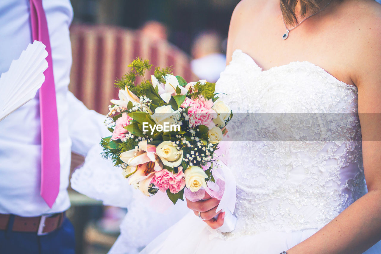 Midsection of woman holding flower bouquet