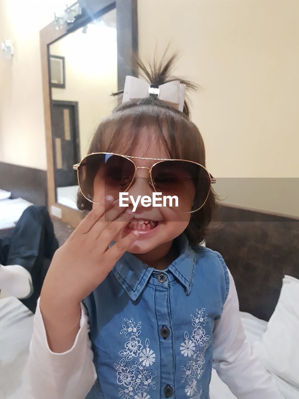 Portrait of smiling girl wearing sunglasses at home