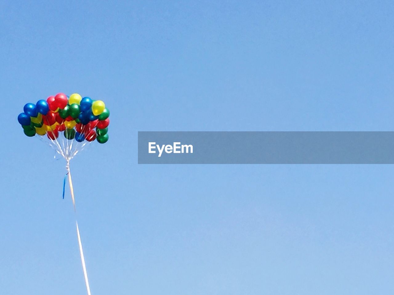 LOW ANGLE VIEW OF BALLOONS AGAINST CLEAR BLUE SKY