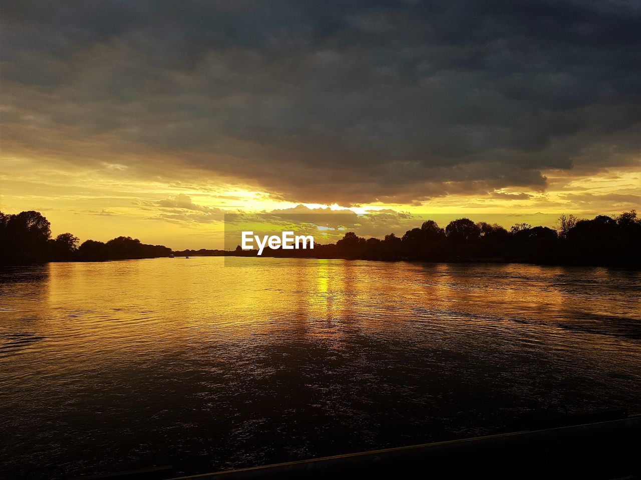 SCENIC VIEW OF LAKE AGAINST ORANGE SKY DURING SUNSET