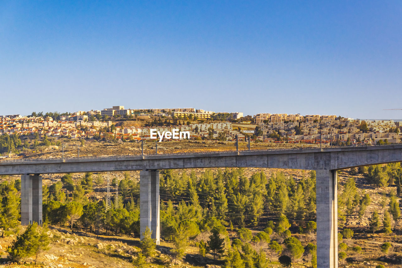 VIEW OF BRIDGE AND CITYSCAPE AGAINST BLUE SKY