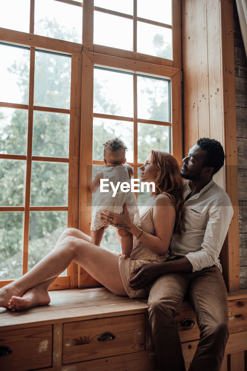 Young couple sitting on window