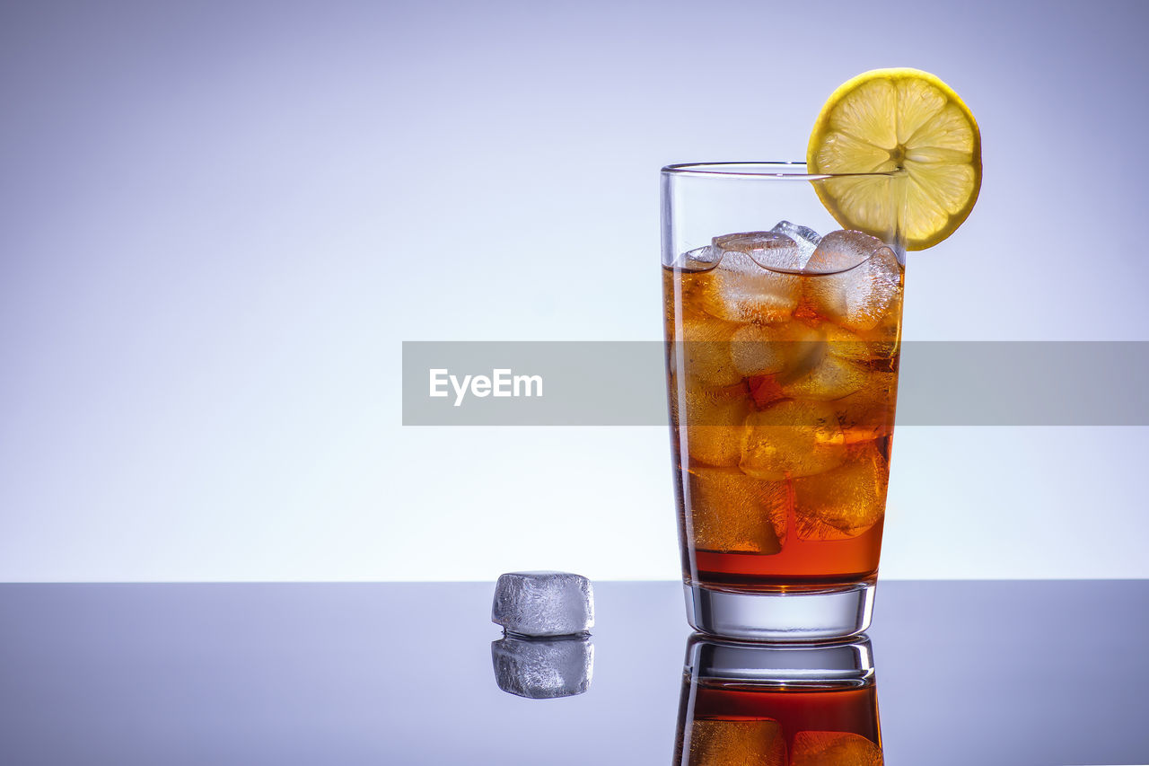 CLOSE-UP OF DRINK AGAINST GLASS