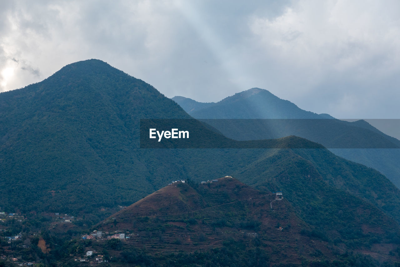 Scenic view of mountains against cloudy sky