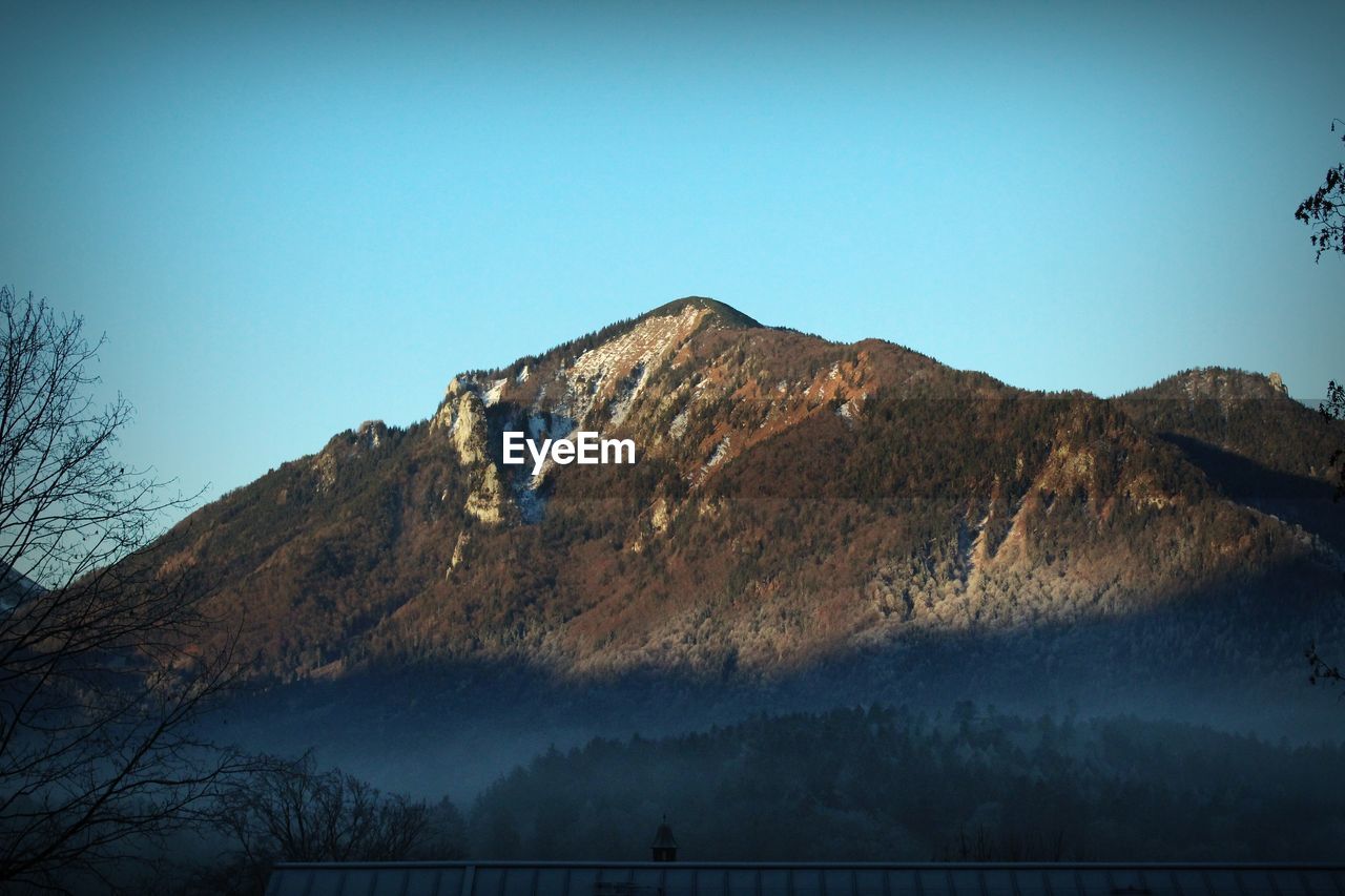 Low angle view of mountains against clear blue sky