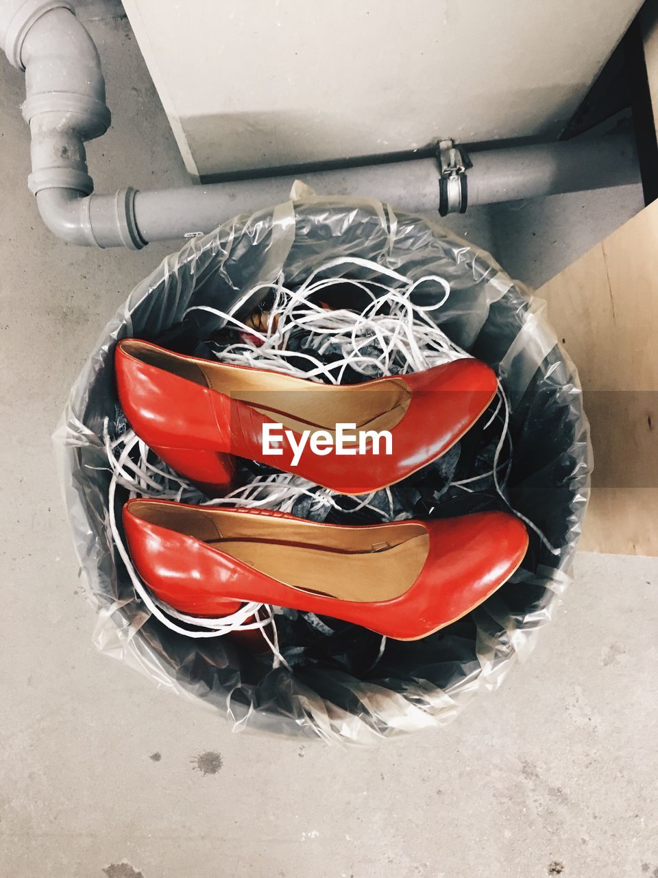 High angle view of red high heels in  dustbin