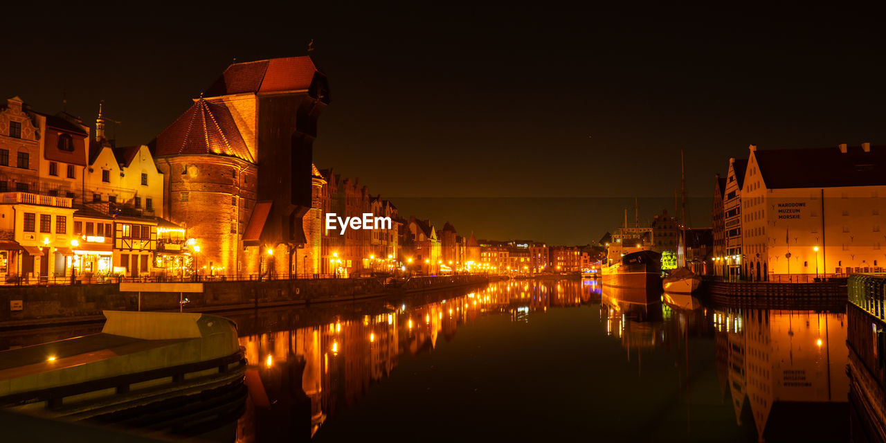 Old town in gdansk at night. the riverside on granary island reflection in moltawa river cityscape