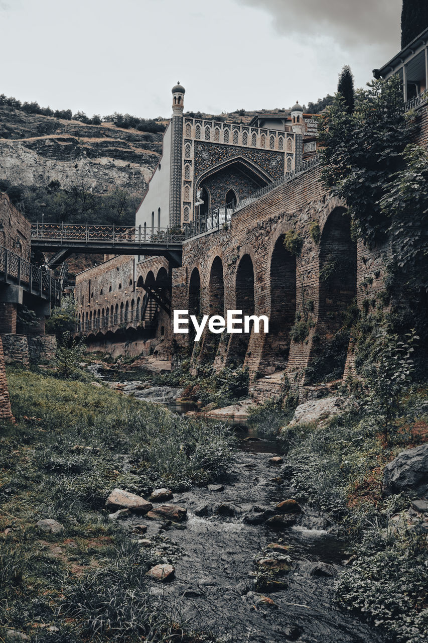 Arch bridge over old building against sky