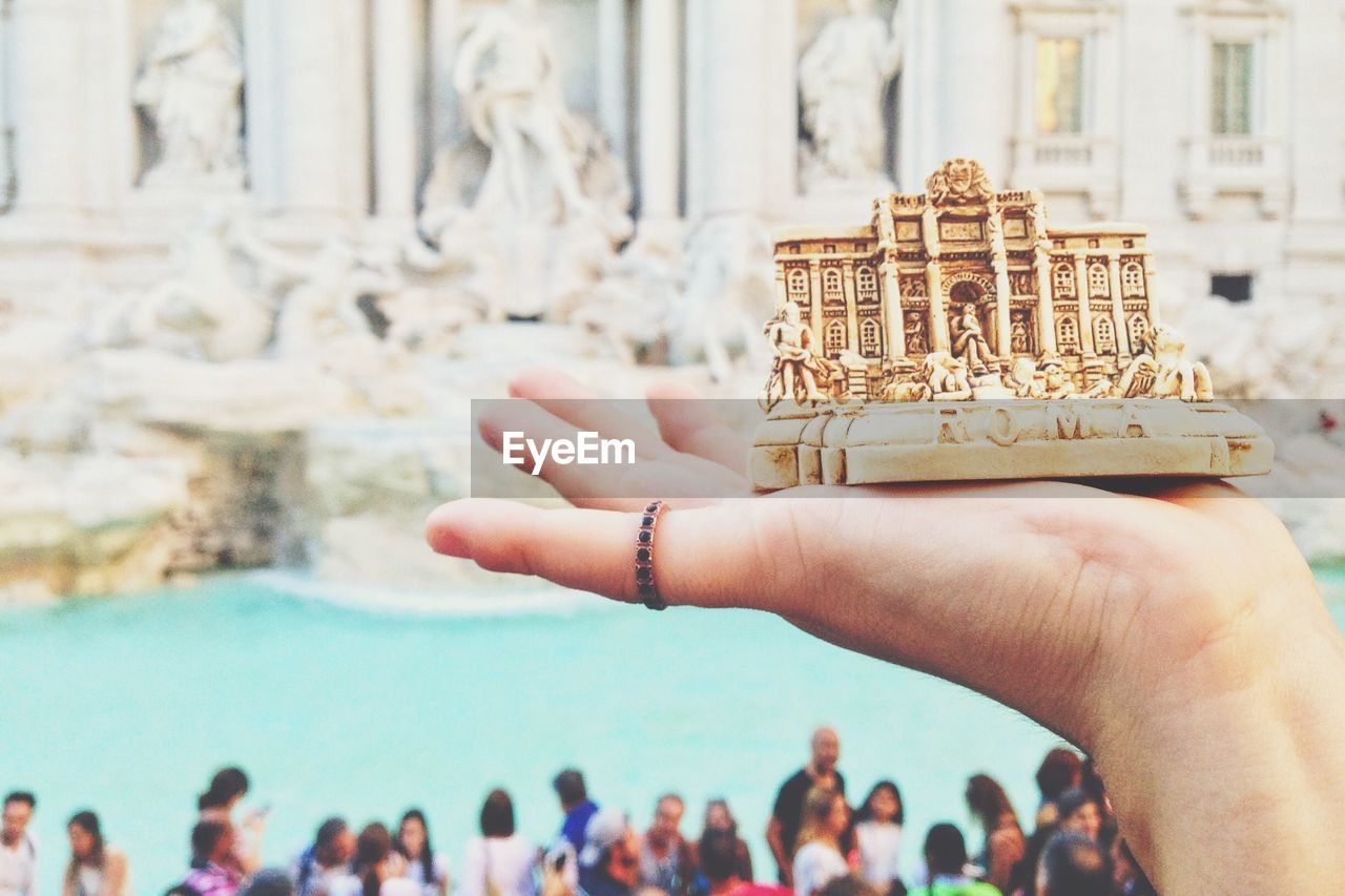 Close-up of person hands holding piazza di trevi statue