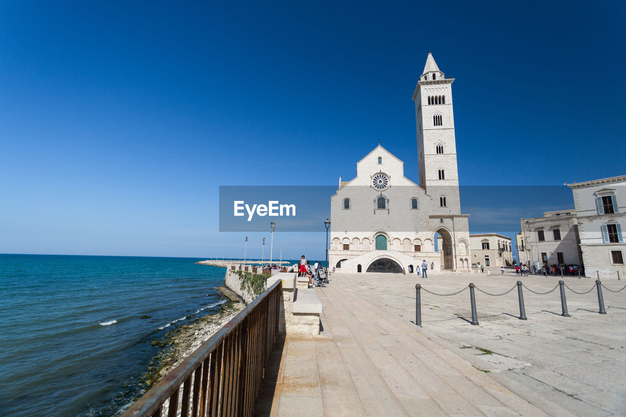 VIEW OF BUILDING BY SEA AGAINST CLEAR SKY