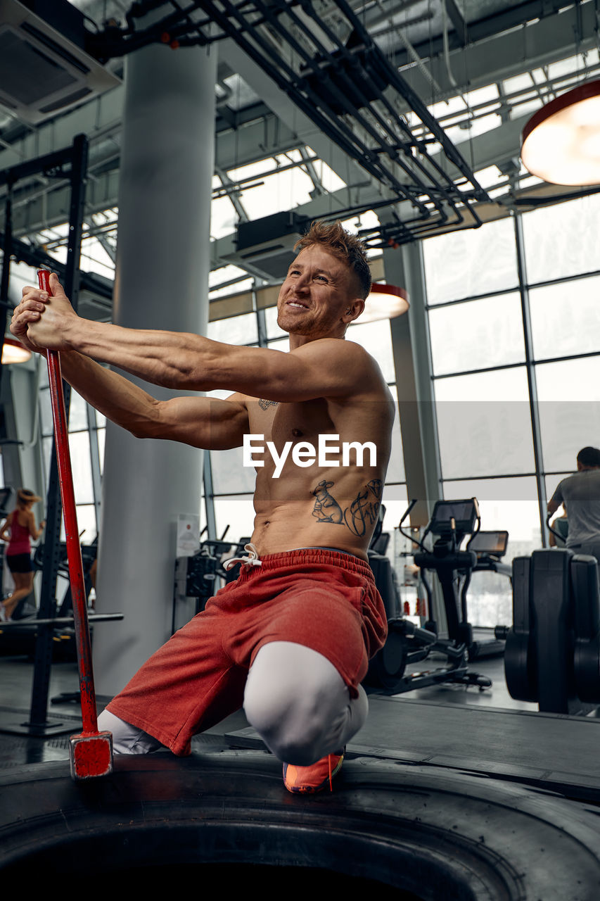 low angle view of shirtless man exercising in gym