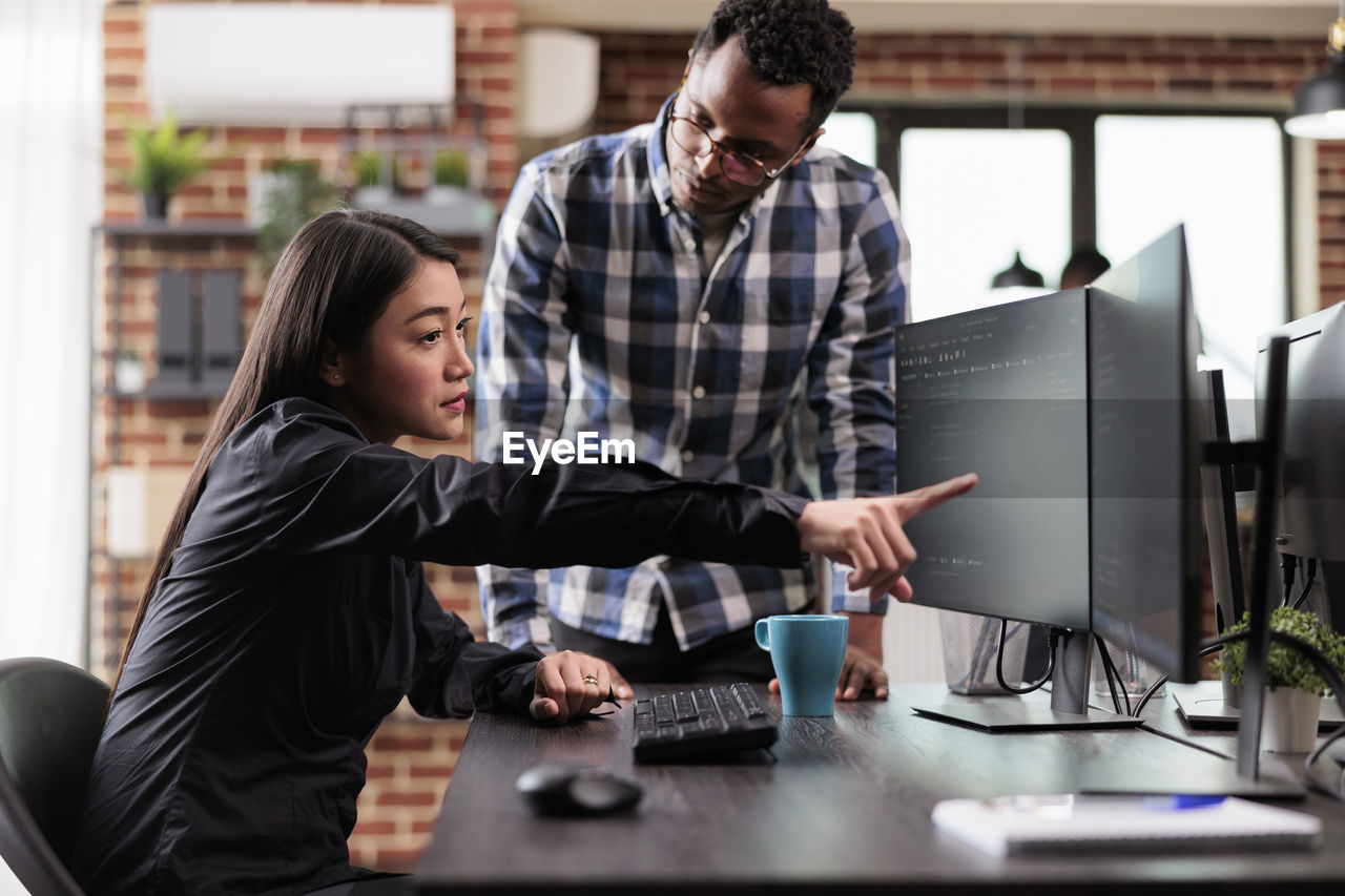 Side view of man using laptop at office