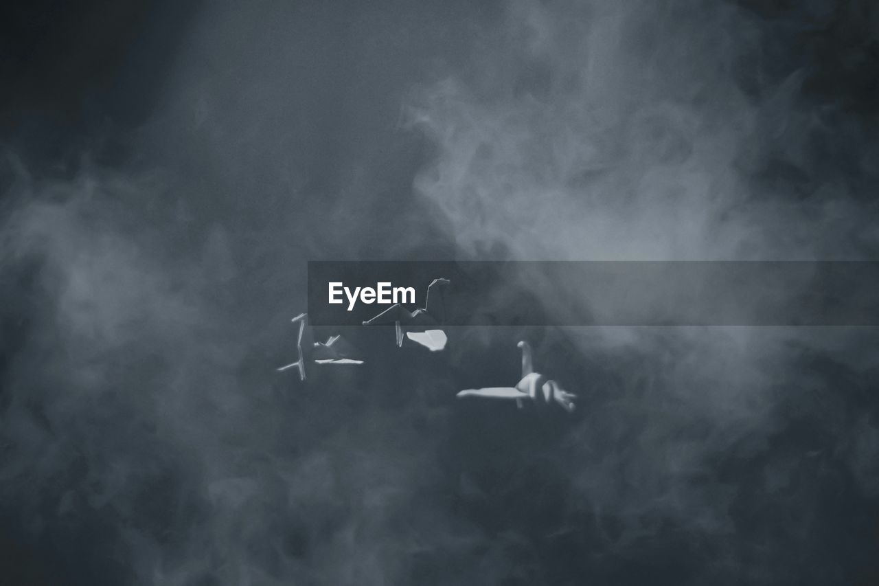 smoke, flying, cloud, darkness, airplane, air vehicle, vehicle, sky, fog, mode of transportation, transportation, motion, mid-air, on the move, no people, monochrome, air show, nature, fighter plane, black and white, teamwork, wing, vapor trail, cooperation