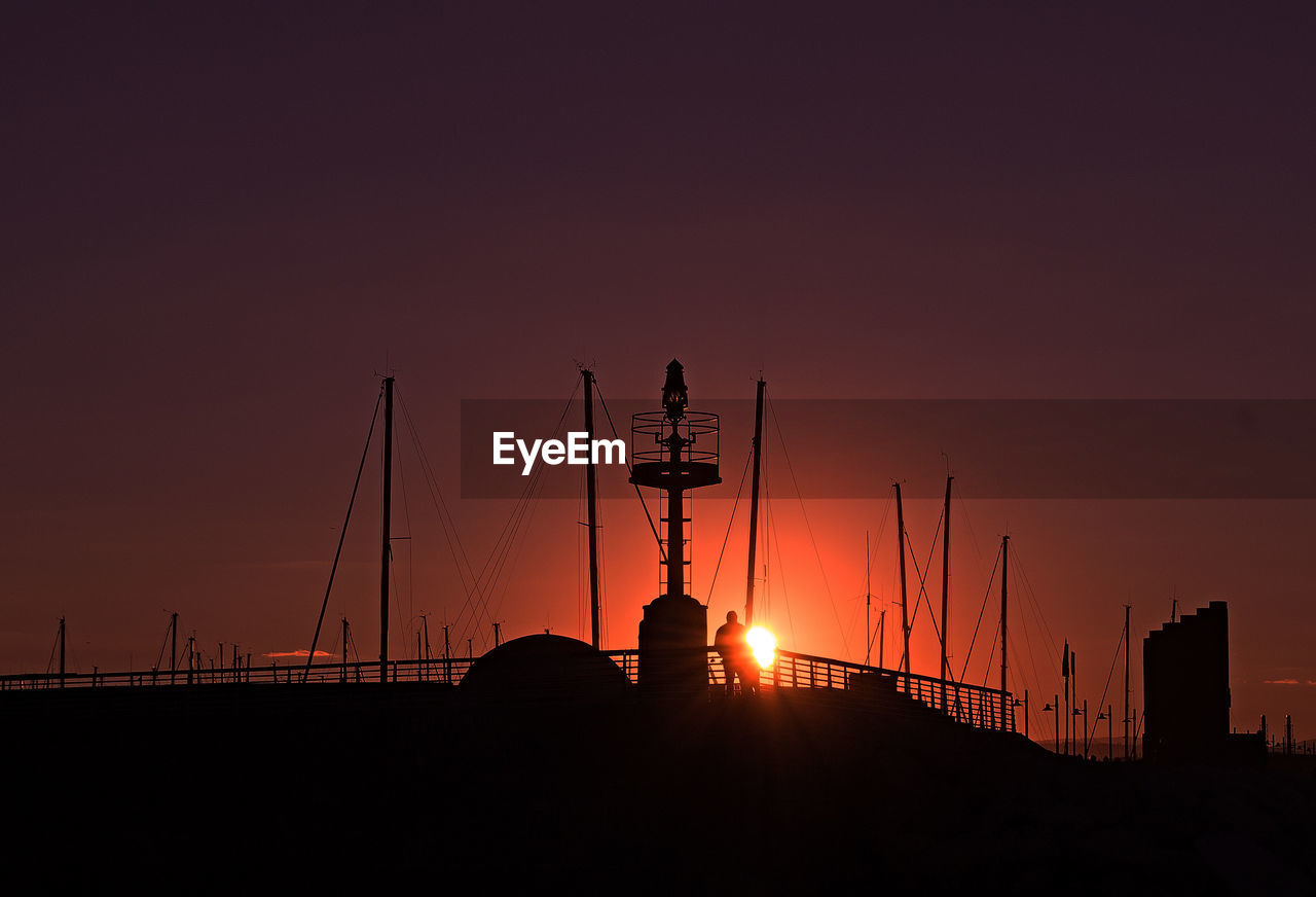 SILHOUETTE CRANE AGAINST SKY DURING SUNSET
