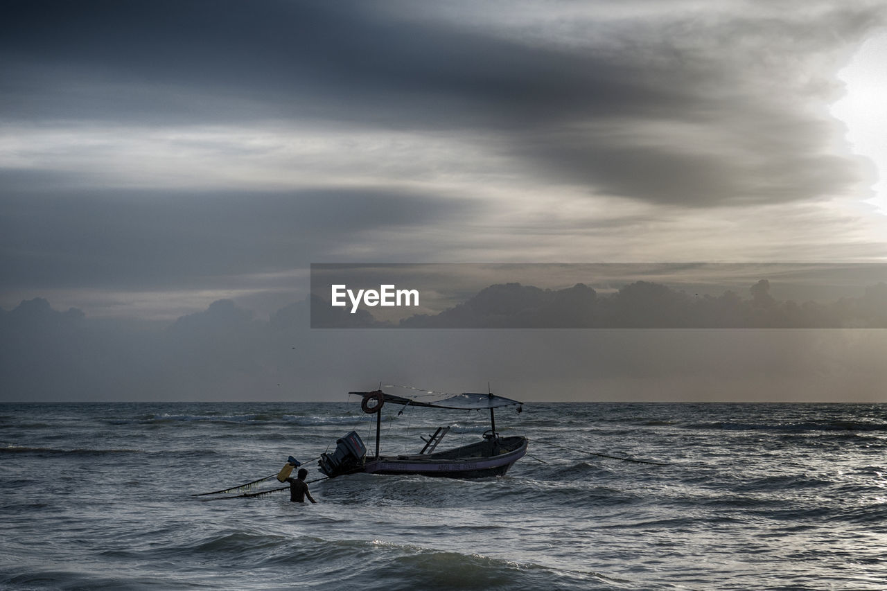 MAN ON SEA AGAINST SKY