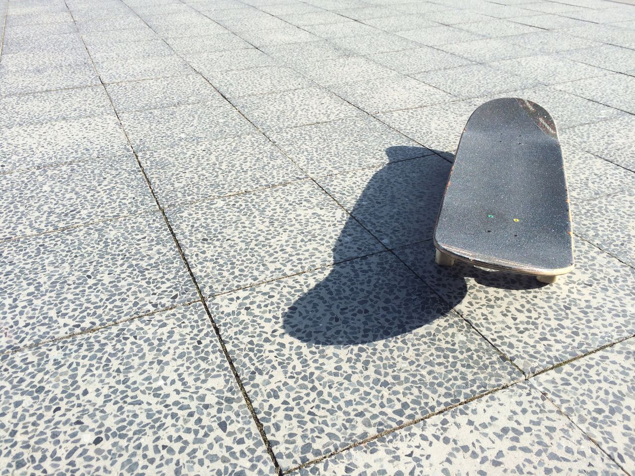 Close-up of skateboard on tiled floor