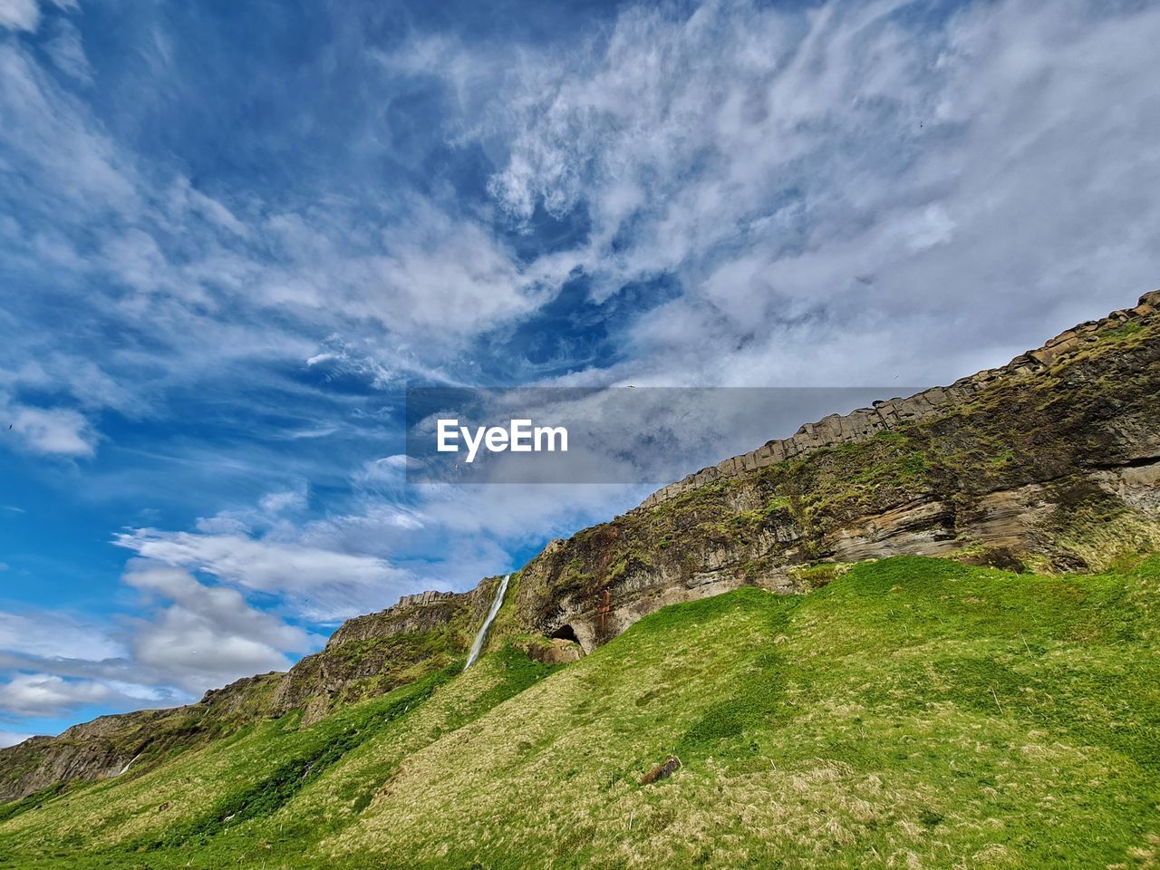 sky, cloud, mountain, nature, environment, landscape, scenics - nature, beauty in nature, mountain range, grass, land, plant, meadow, highland, green, non-urban scene, tranquility, no people, rural area, travel destinations, travel, tranquil scene, blue, plateau, ridge, grassland, outdoors, tourism, rock, day, field, idyllic, rural scene, plain, valley, summer, cliff, terrain, social issues, tree, activity