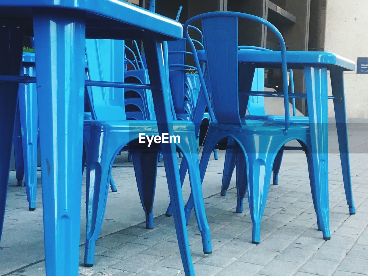 EMPTY CHAIRS AND TABLE AGAINST BUILDING