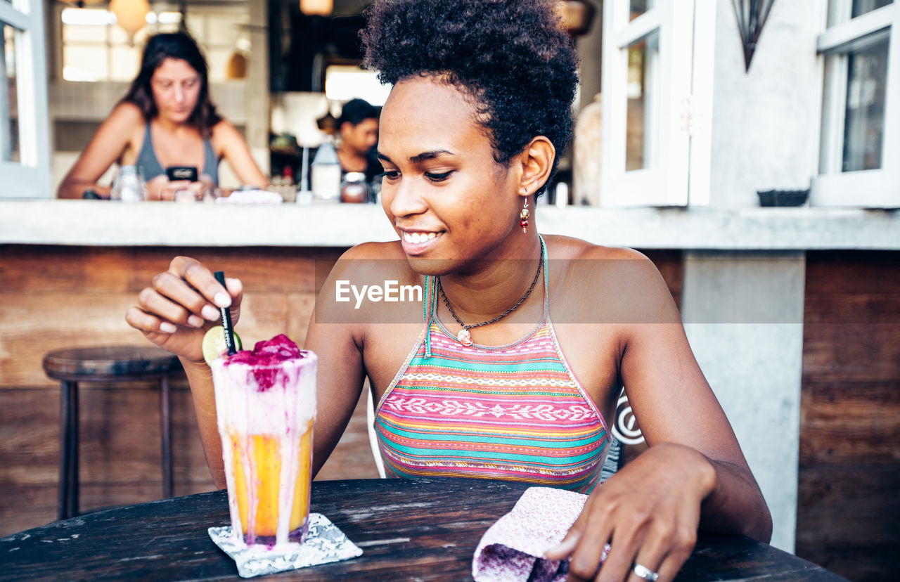 Close-up of young woman having drink on table