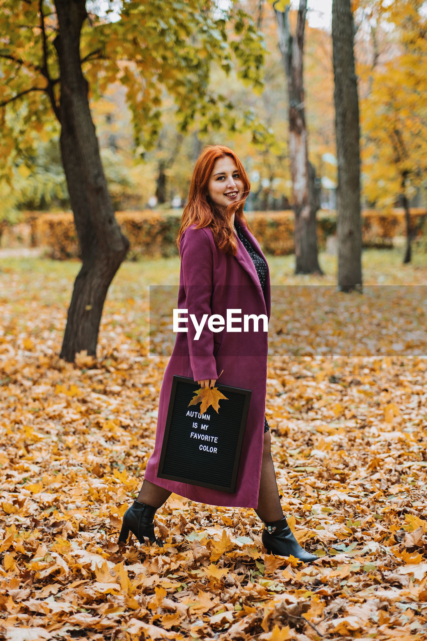 Hello autumn. red hair girl with letter message board with text autumn is my favorite color