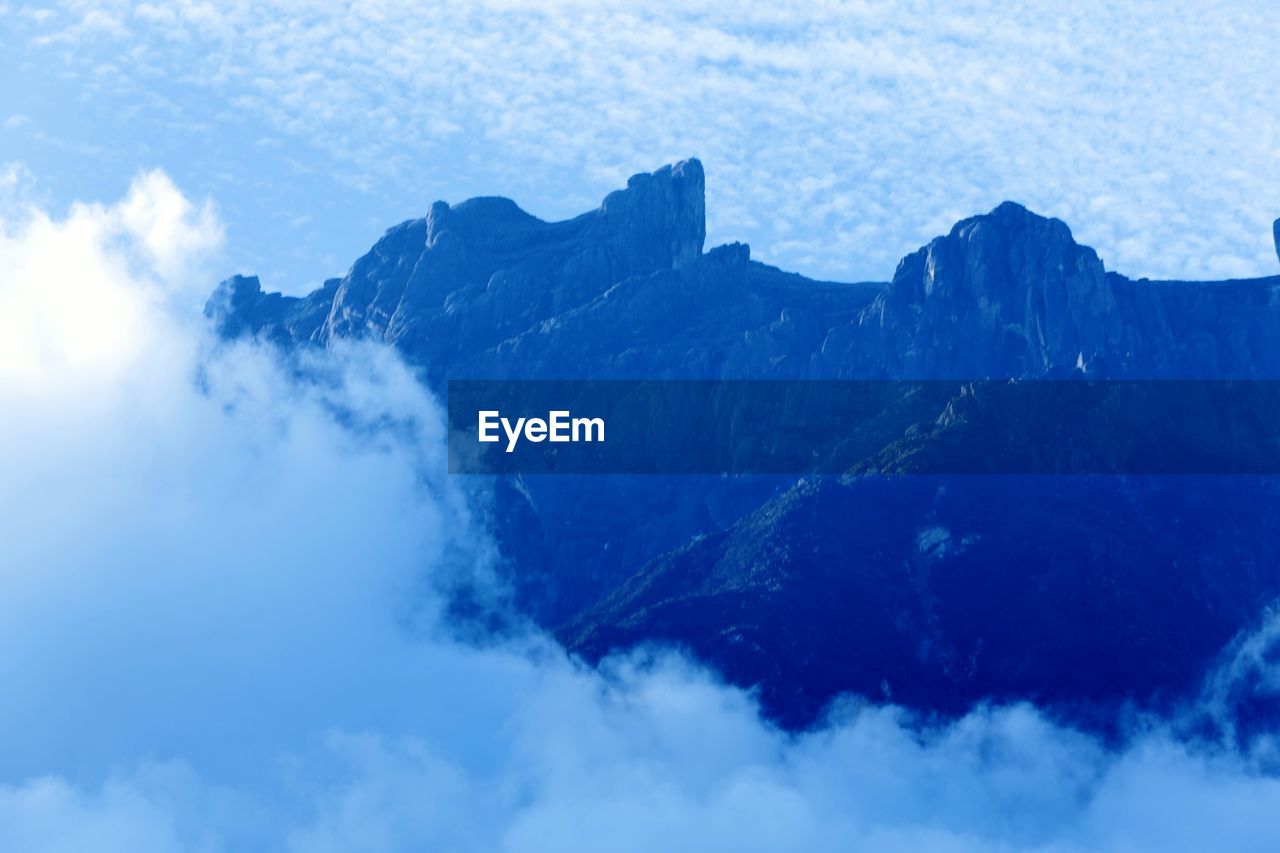 PANORAMIC VIEW OF MOUNTAINS AGAINST BLUE SKY