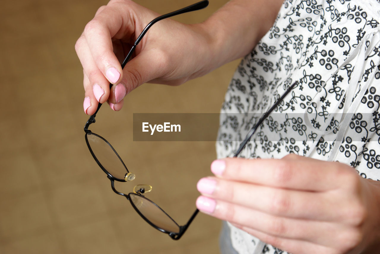 Midsection of woman holding eyeglasses