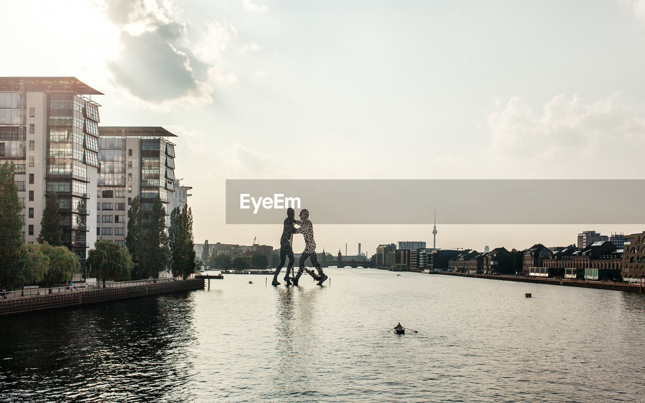 Molecule man structure in river against sky