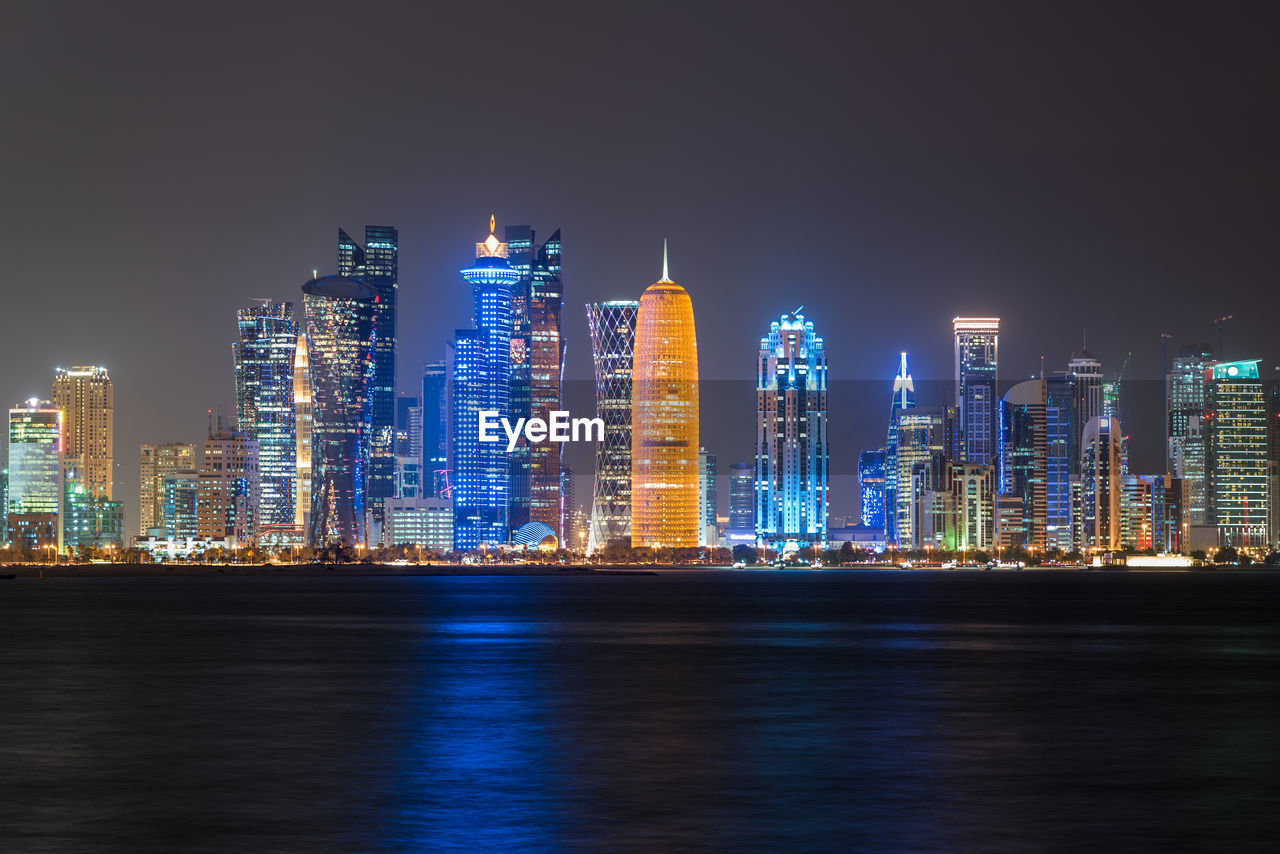 Illuminated buildings against sky at night