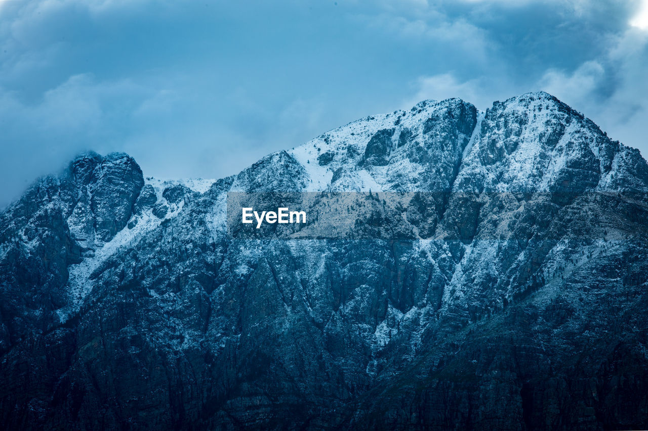 low angle view of snowcapped mountains against sky