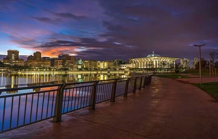 ILLUMINATED CITY AGAINST CLOUDY SKY