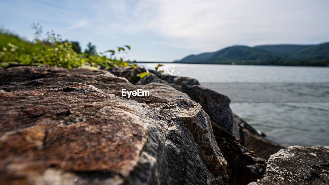 Close-up of rocks on shore against sky