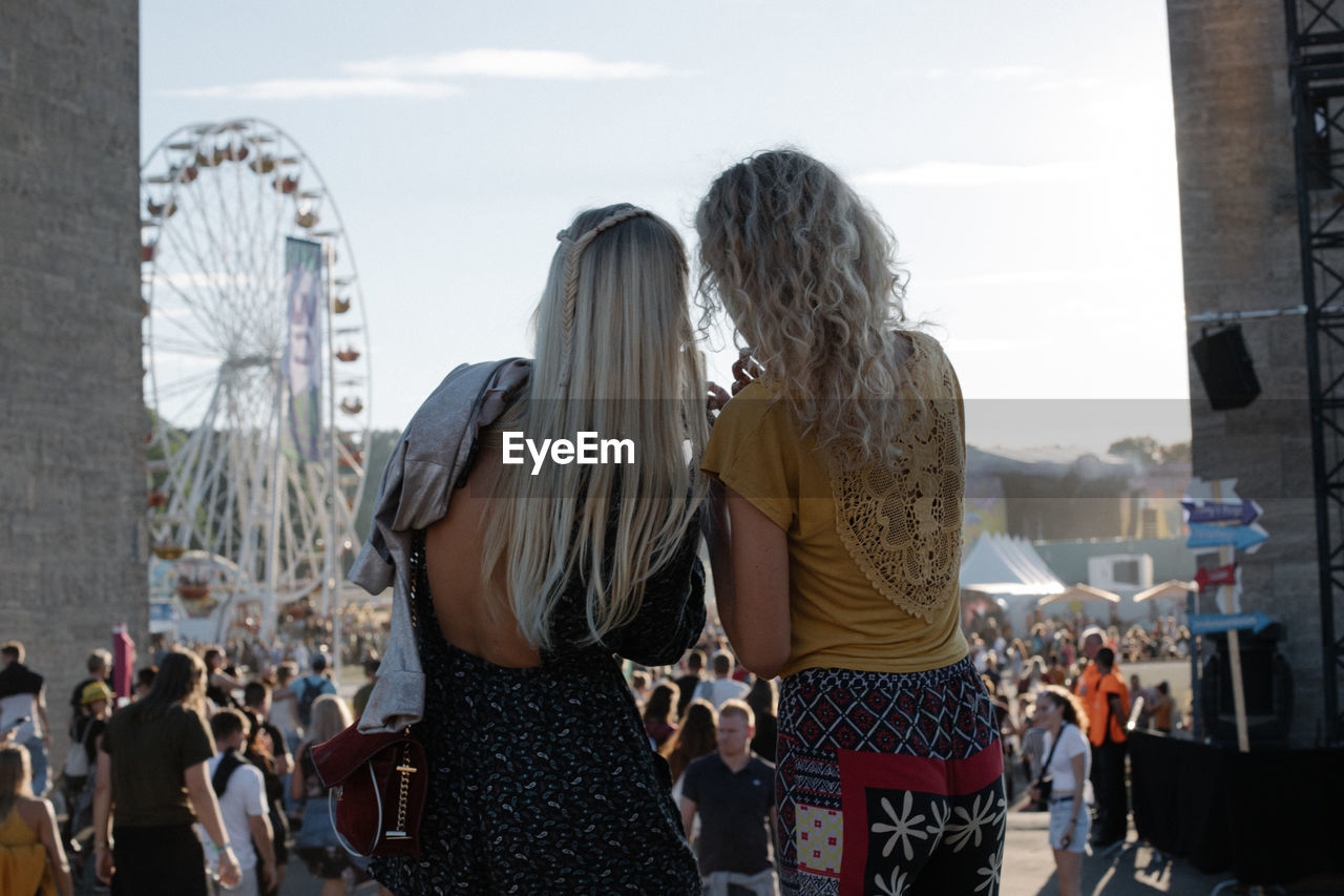REAR VIEW OF PEOPLE WATCHING AMUSEMENT PARK