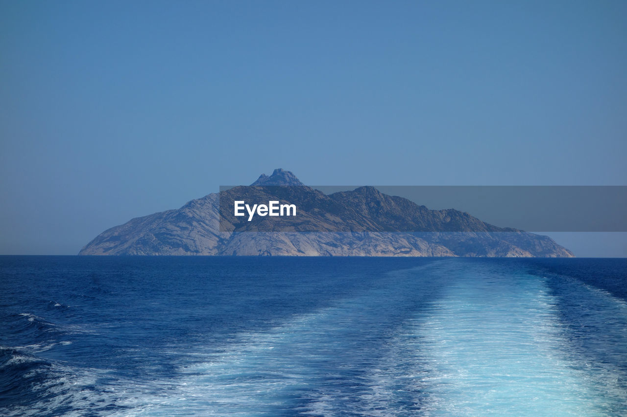scenic view of sea and mountains against clear sky