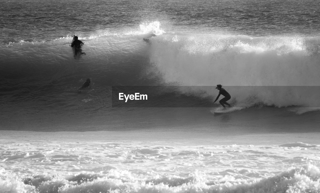 Friends surfing in sea