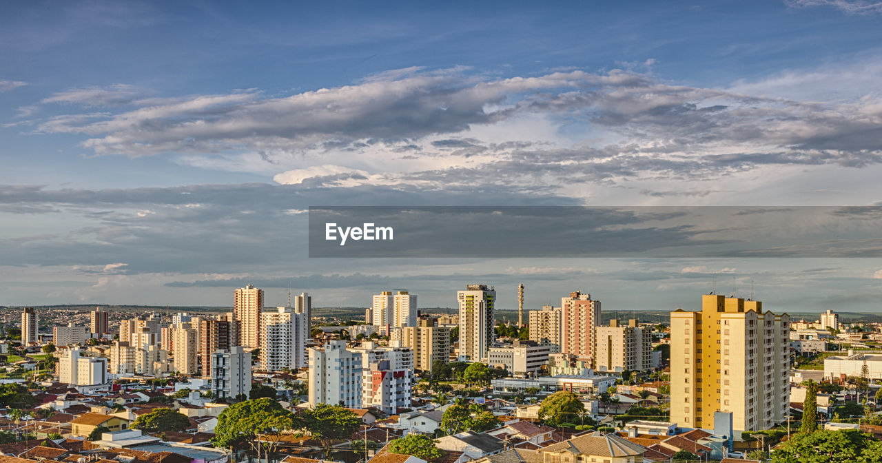 Aerial view of buildings in city against sky