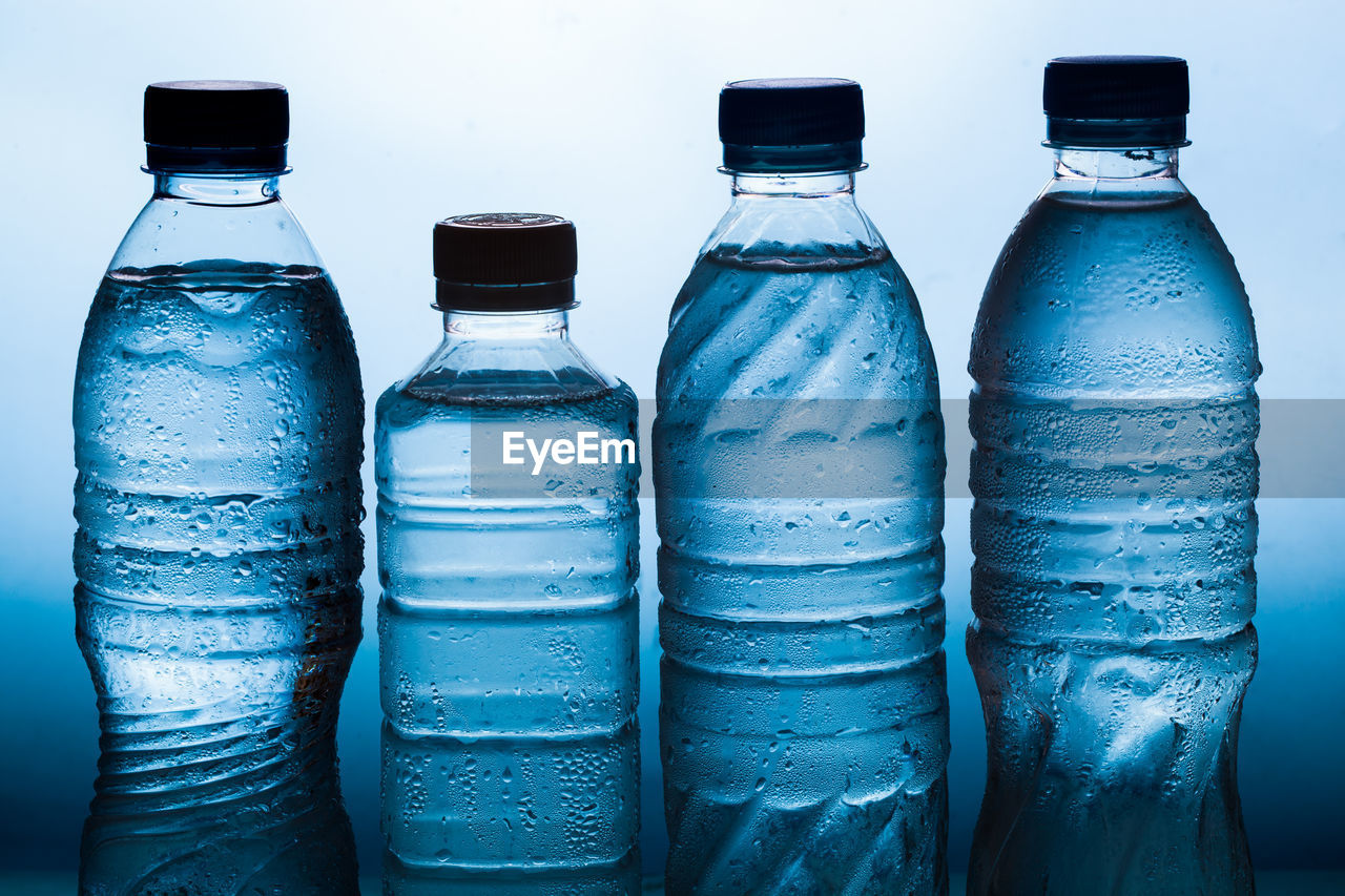 CLOSE-UP OF BOTTLES ON BLUE TABLE