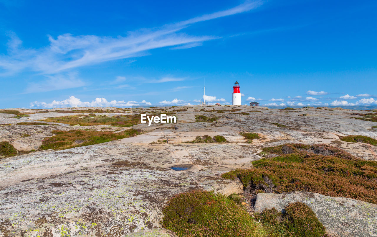 LIGHTHOUSE AMIDST ROCKS AND BUILDING