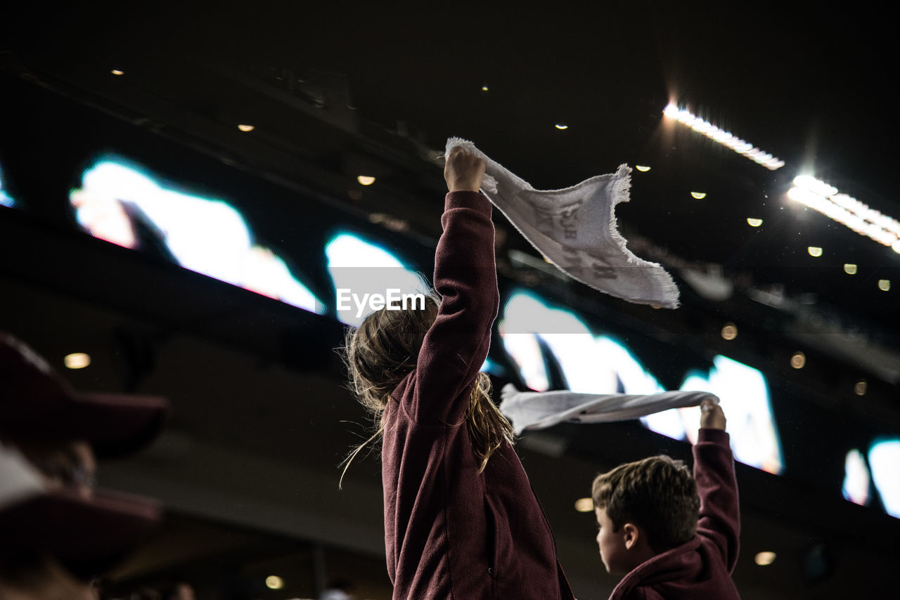 LOW ANGLE VIEW OF PEOPLE AT CONCERT