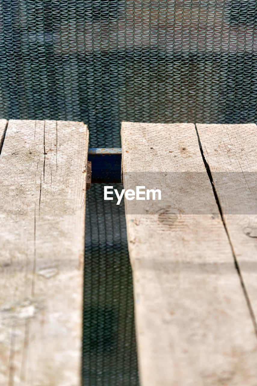 HIGH ANGLE VIEW OF BENCH ON SWIMMING POOL