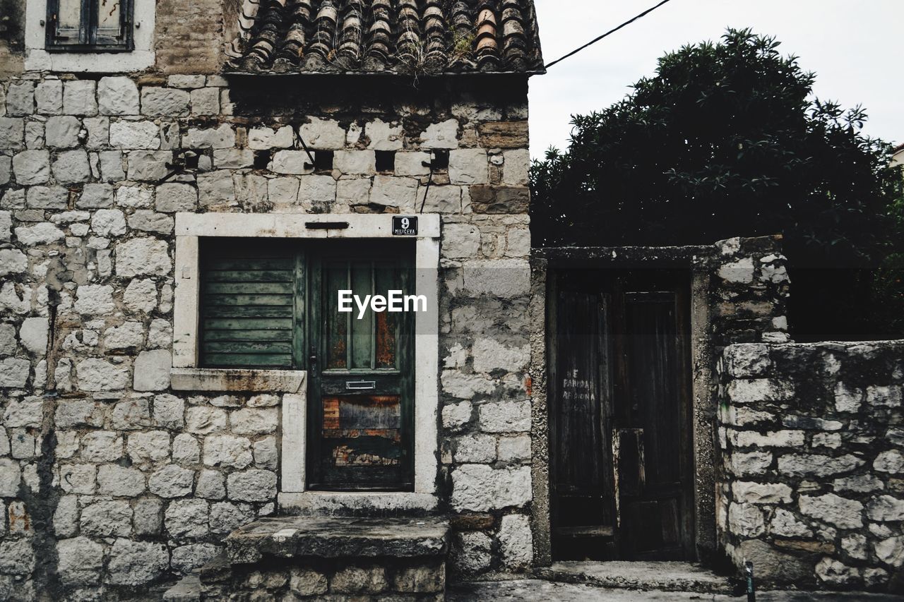 EXTERIOR OF OLD HOUSE WITH CLOSED DOOR