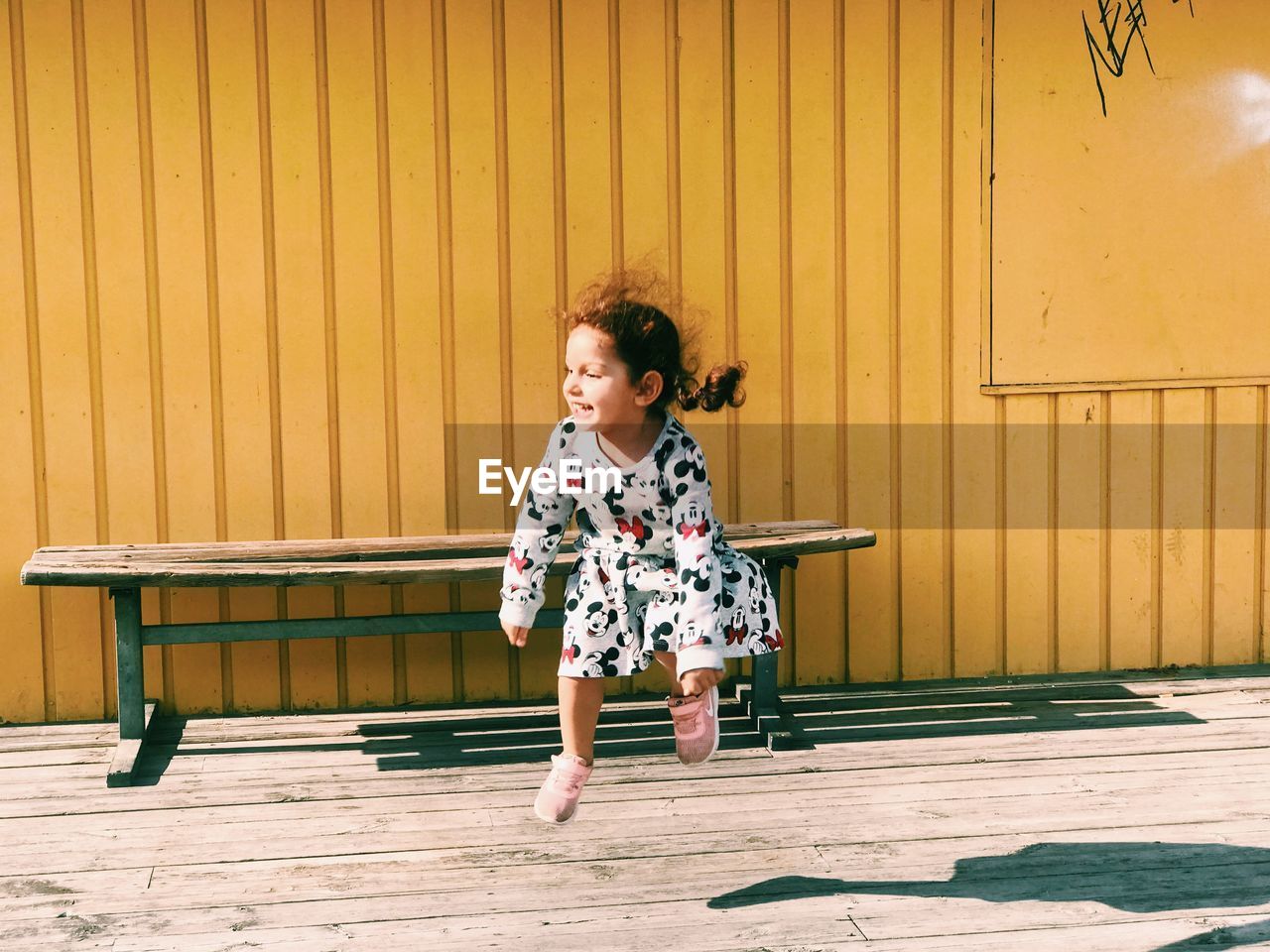 FULL LENGTH OF A GIRL STANDING ON YELLOW WOOD