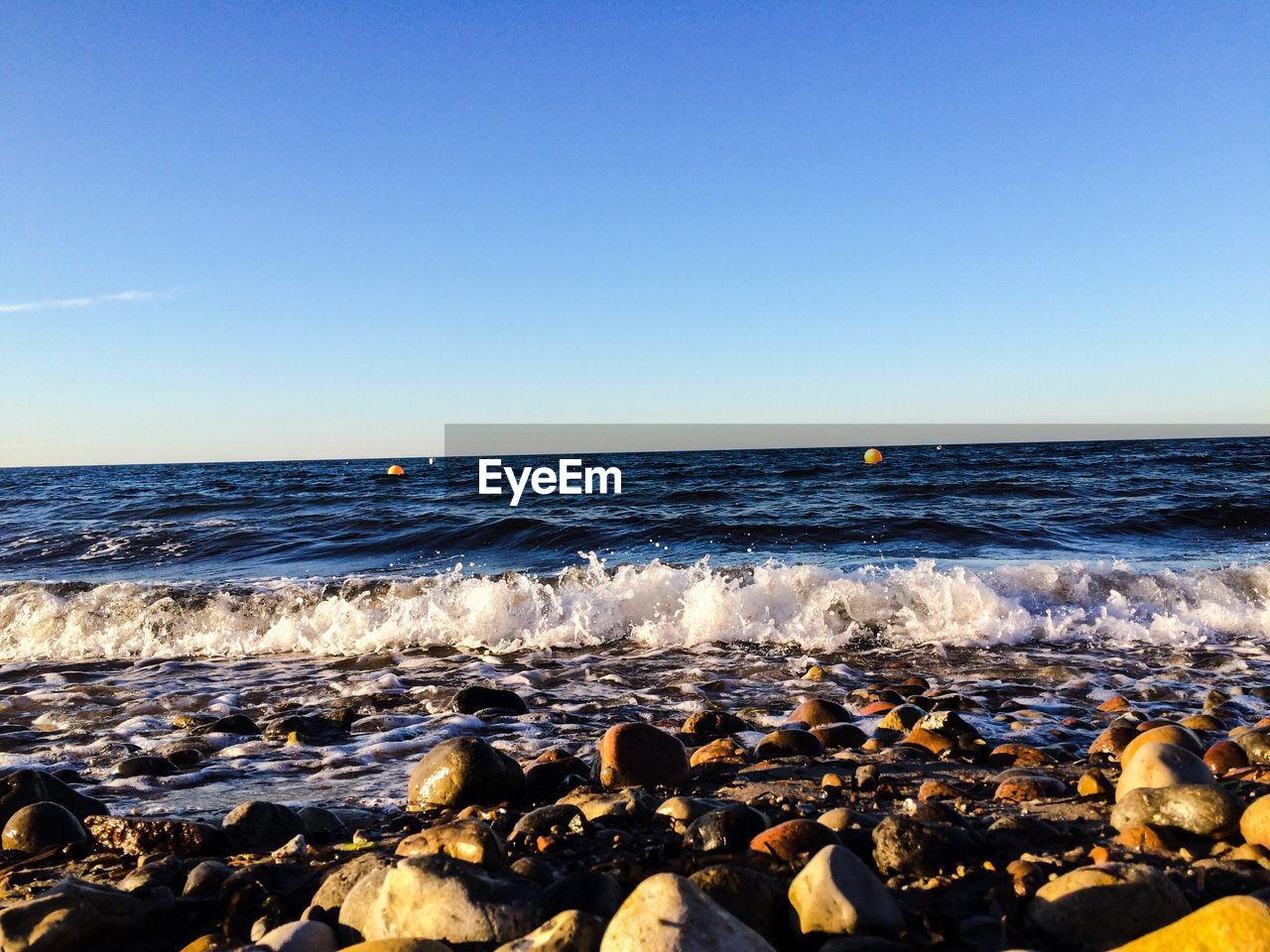 Scenic view of sea against clear blue sky