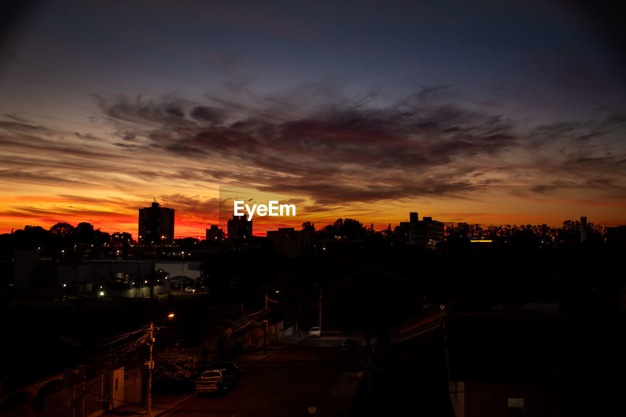 High angle view of silhouette buildings against sky during sunset