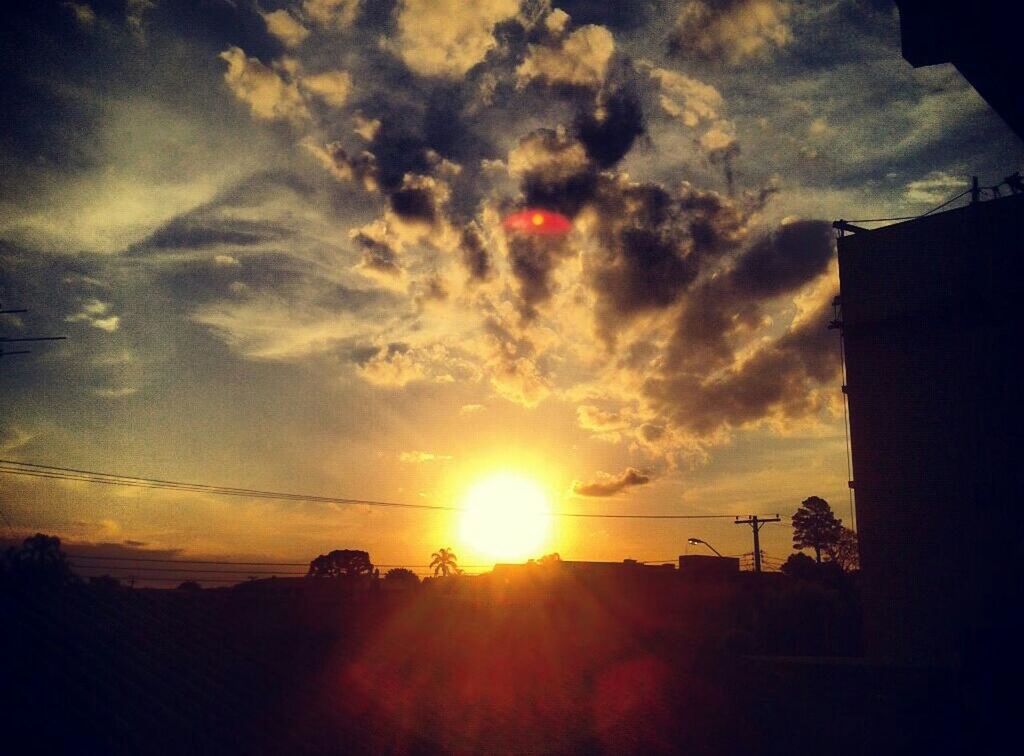 SUN SHINING THROUGH CLOUDS AT SUNSET